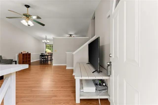 a dining room with wooden floor table and chairs
