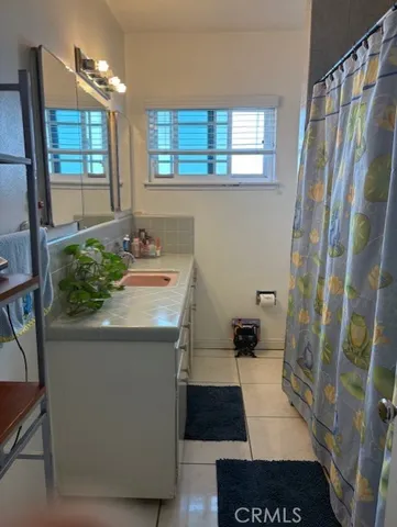 a bathroom with a sink a toilet a mirror and shower