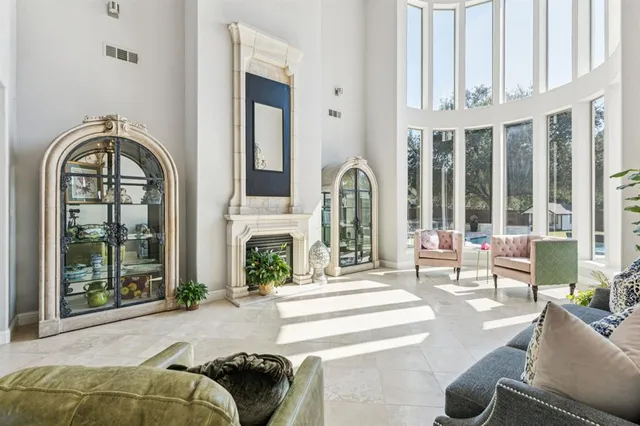 a living room with fireplace furniture and a large window