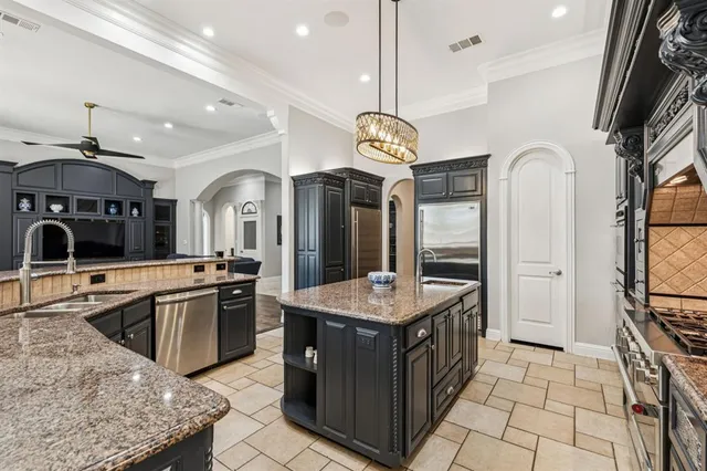 a kitchen with stainless steel appliances granite countertop a sink a stove and a refrigerator