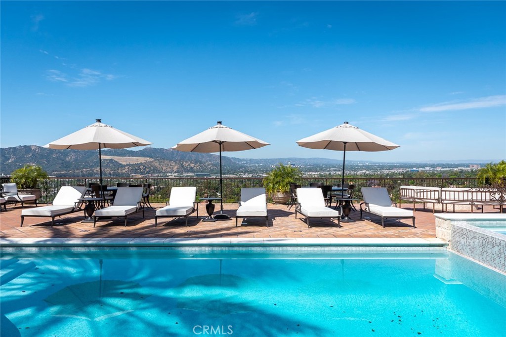 330 Kempton Road Glendale, CA 91202 - Photo 59 of 75 a view of a swimming pool with lawn chairs under an umbrella