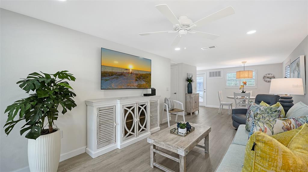 6020 Midnight Pass Road, Unit 63 Sarasota, FL 34242 - Photo 12 of 52 a living room with furniture a flat screen tv and a potted plant