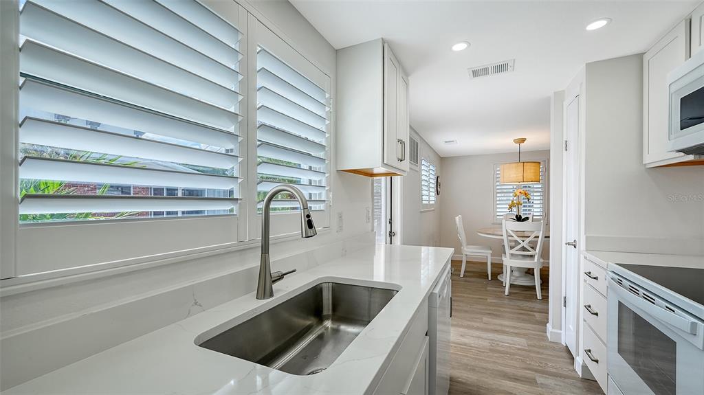 6020 Midnight Pass Road, Unit 63 Sarasota, FL 34242 - Photo 14 of 52 a kitchen with a sink and a refrigerator