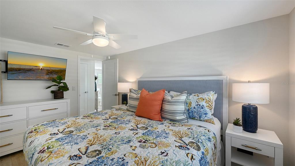 6020 Midnight Pass Road, Unit 63 Sarasota, FL 34242 - Photo 16 of 52 a bedroom with a bed and a dresser with rug