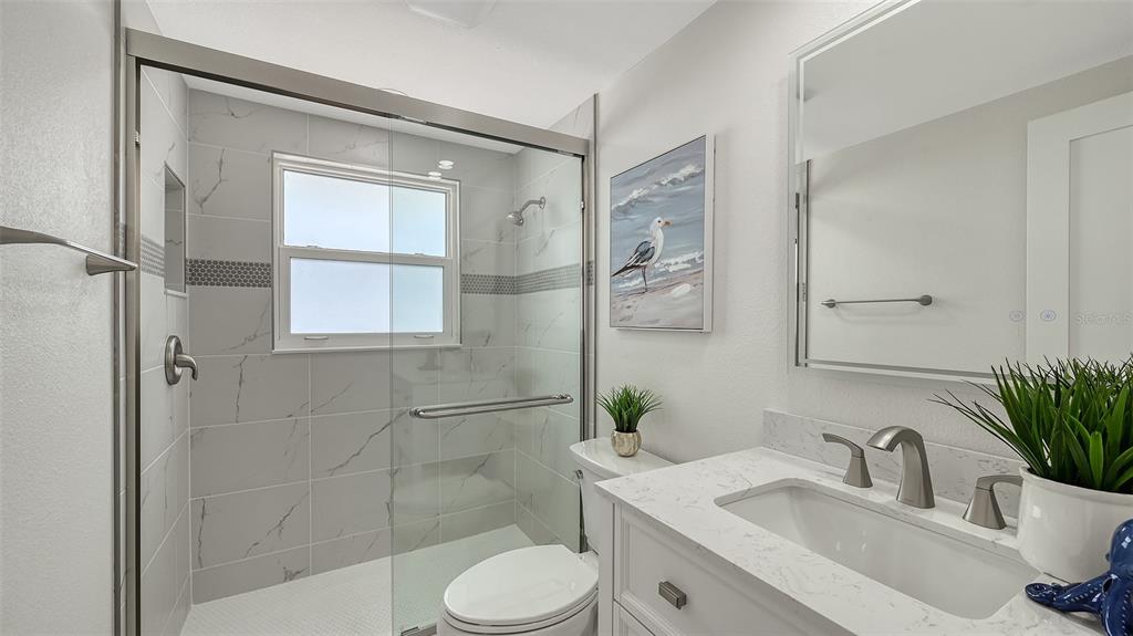 6020 Midnight Pass Road, Unit 63 Sarasota, FL 34242 - Photo 17 of 52 a bathroom with a sink toilet a mirror and shower