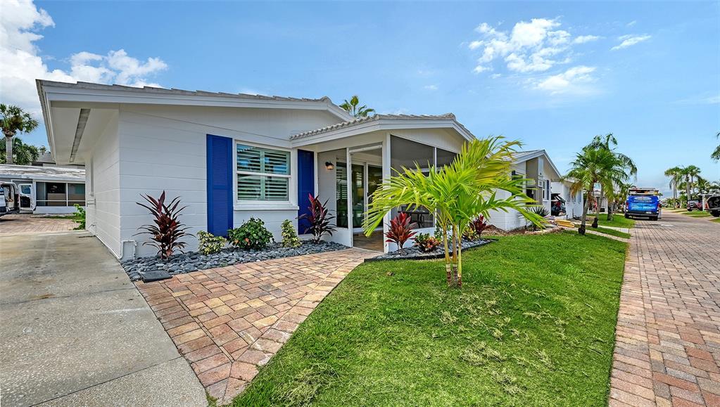 6020 Midnight Pass Road, Unit 63 Sarasota, FL 34242 - Photo 19 of 52 a front view of a house with a yard and potted plants