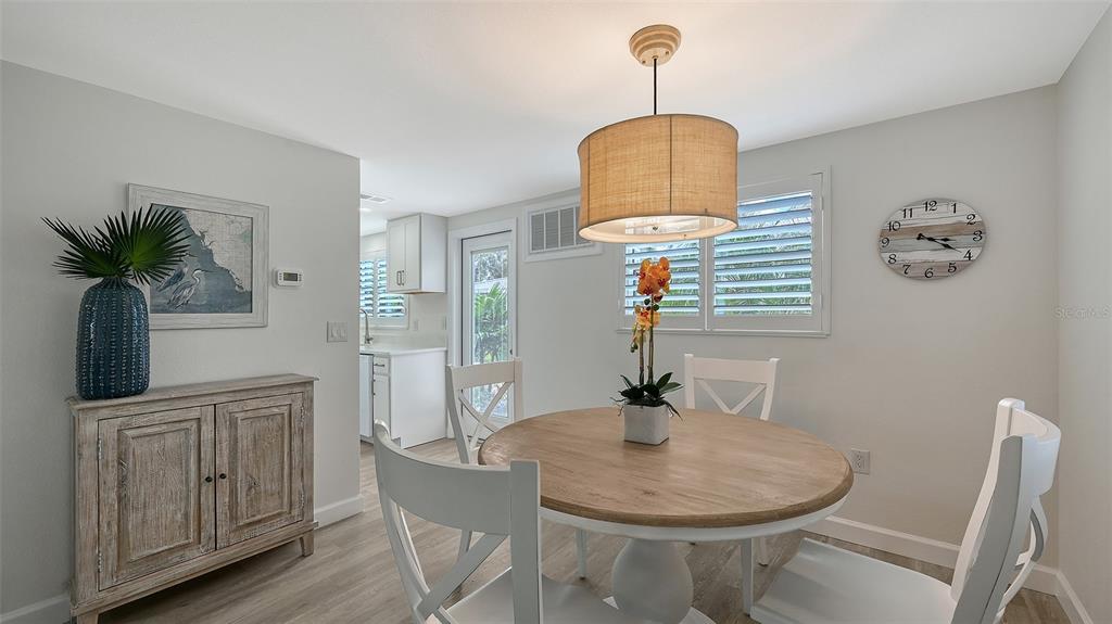 6020 Midnight Pass Road, Unit 63 Sarasota, FL 34242 - Photo 3 of 52 a dining room with furniture and wooden floor