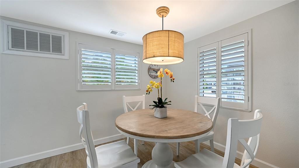 6020 Midnight Pass Road, Unit 63 Sarasota, FL 34242 - Photo 4 of 52 a dining room with chandelier fan and wooden floor