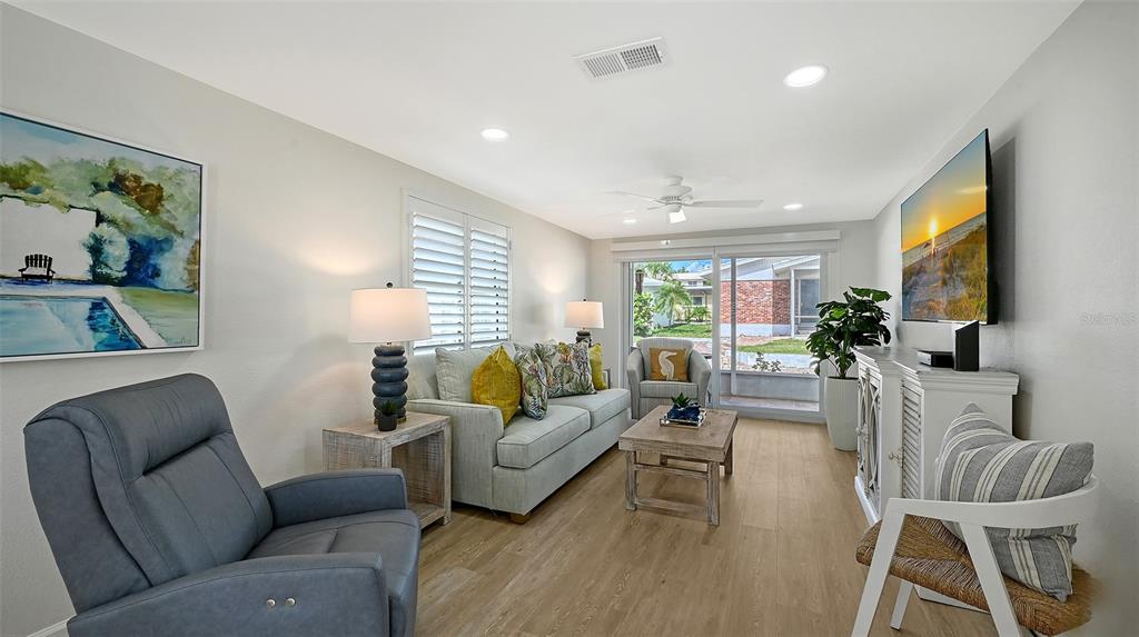 6020 Midnight Pass Road, Unit 63 Sarasota, FL 34242 - Photo 6 of 52 a living room with furniture and a flat screen tv