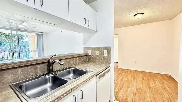 a kitchen with granite countertop a stove a sink and a refrigerator