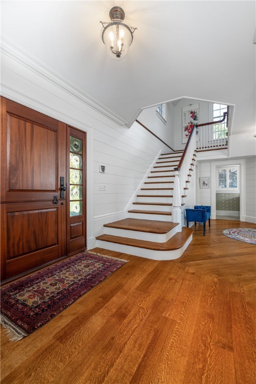415 Poppasquash Road Bristol, RI 02809 - Photo 12 of 50 Stunning shiplap foyer with extra wide custom staircase with lighthouse carved millwork. Half bath is off in the distance.