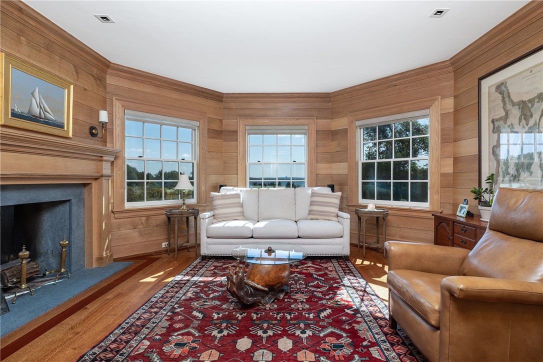 415 Poppasquash Road Bristol, RI 02809 - Photo 23 of 50 Exquisite family room with 4" oak floors, oak shiplap, soapstone lined fireplace in a unique octagon shape offers more water views.