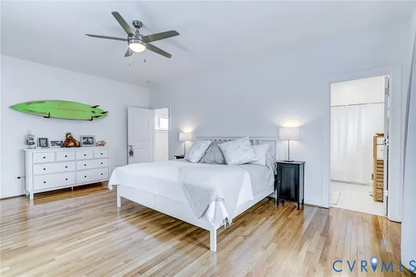 a spacious bedroom with a bed and a wooden floor