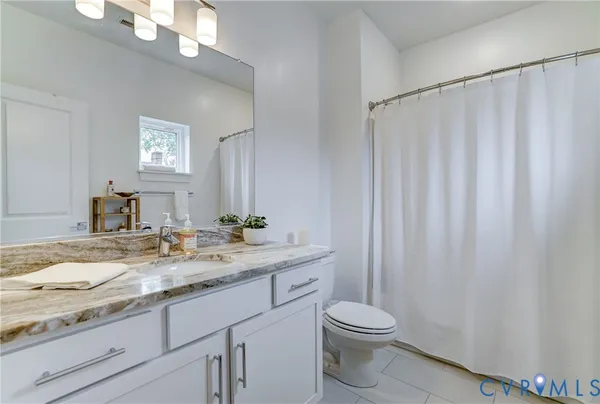 a bathroom with a granite countertop sink toilet and mirror