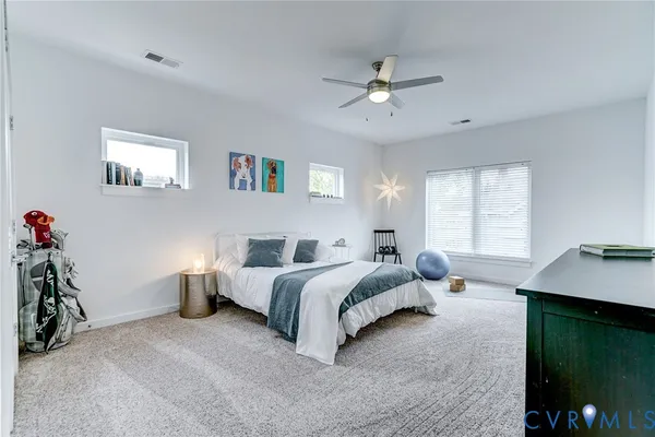 a spacious bedroom with a bed and a chandelier