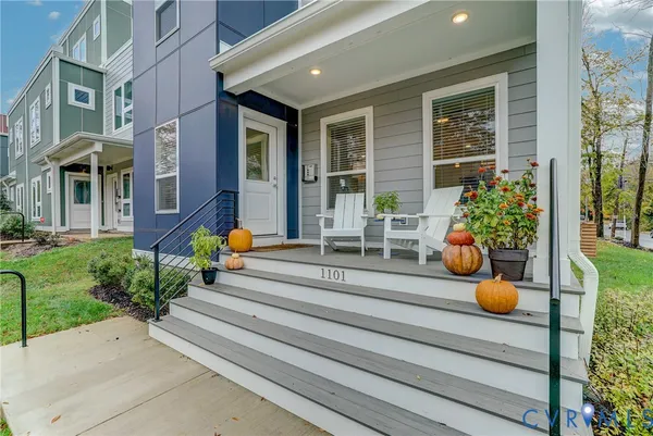 a view of a building with potted plants and chairs in front of building