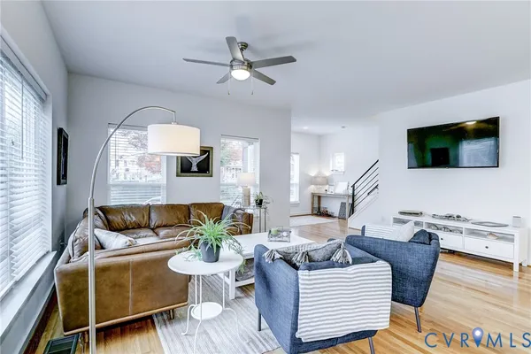 a living room with furniture a large window and a flat screen tv