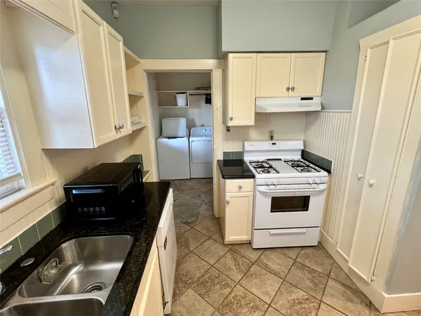 a kitchen with white cabinets and white appliances
