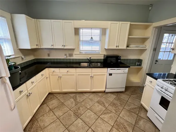 a kitchen with granite countertop white cabinets and white appliances