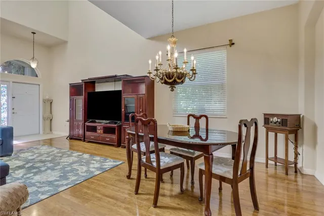 a view of a dining room with furniture a chandelier and wooden floor