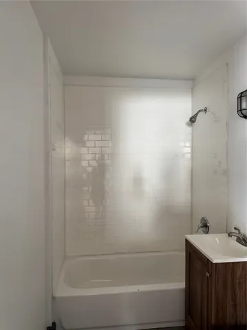 a bathroom with a bathtub sink vanity and toilet