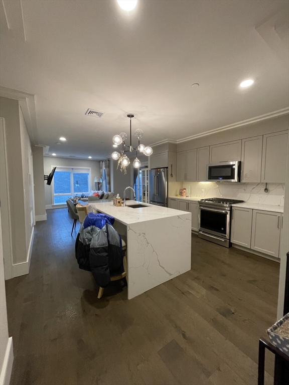 214 Market Street, Unit 301 Boston, MA 02135 - Photo 2 of 11 a large white kitchen with lots of counter space a sink and appliances