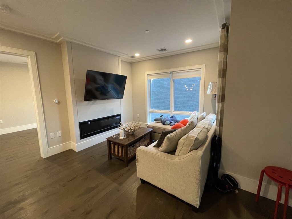 214 Market Street, Unit 301 Boston, MA 02135 - Photo 3 of 11 a living room with furniture and a flat screen tv
