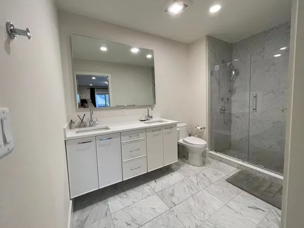 a spacious bathroom with a double vanity sink mirror and toilet