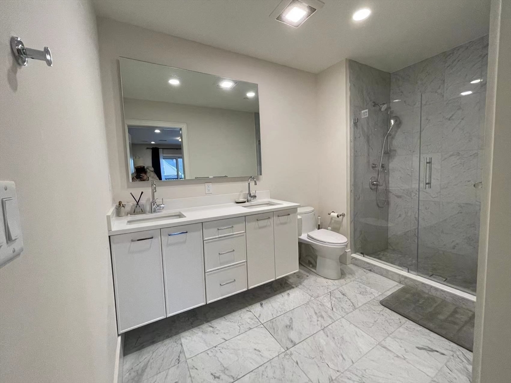 214 Market Street, Unit 301 Boston, MA 02135 - Photo 5 of 11 a spacious bathroom with a double vanity sink mirror and toilet