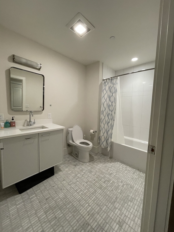 214 Market Street, Unit 301 Boston, MA 02135 - Photo 10 of 11 a bathroom with a double vanity sink toilet and a mirror