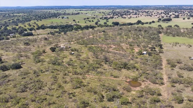 an aerial view of house with yard and mountain view in back