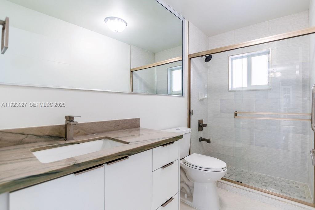 3425 Southwest 69th Avenue Miami, FL 33155 - Photo 21 of 40 a bathroom with a granite countertop sink a toilet and shower