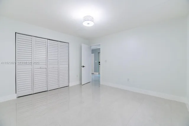 an empty room with closet and natural light