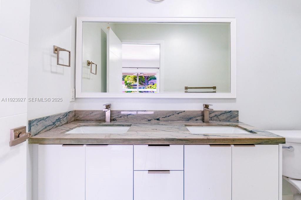 3425 Southwest 69th Avenue Miami, FL 33155 - Photo 34 of 40 a bathroom with a granite countertop sink and a mirror