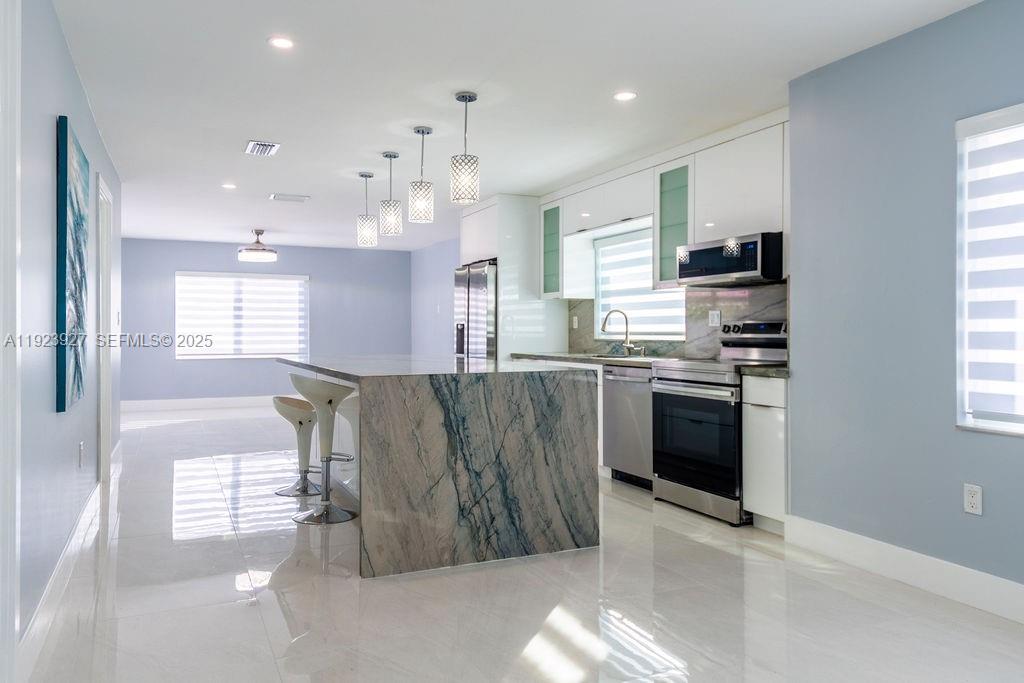 3425 Southwest 69th Avenue Miami, FL 33155 - Photo 6 of 40 a kitchen with stainless steel appliances granite countertop a refrigerator a sink a stove top oven a sink and a window