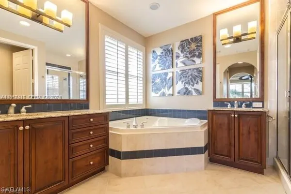 a spacious bathroom with a tub sink and mirror