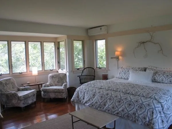 a bedroom with a bed couch and a large window