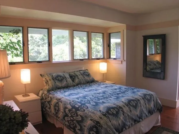 a bed sitting in a bedroom next to a window