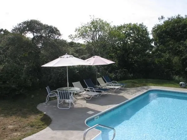 a white house with a table and chairs under an umbrella
