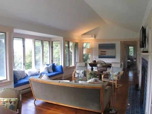 a living room with fireplace furniture and floor to ceiling windows