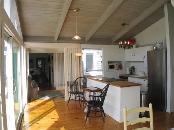 a kitchen with stainless steel appliances kitchen island granite countertop a table chairs sink and cabinets