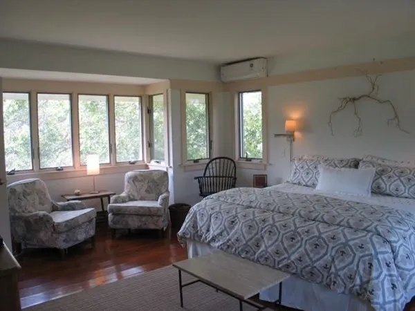 a bedroom with a bed couch and a large window