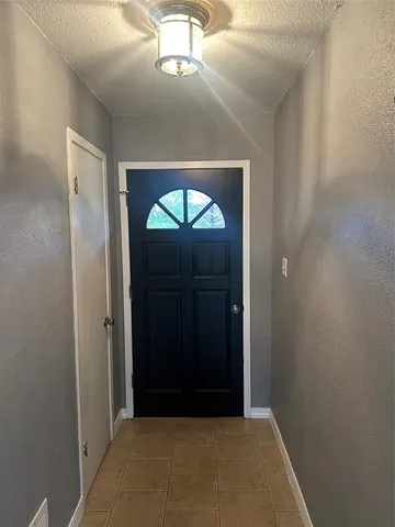 a view of an empty room with a fireplace and a window