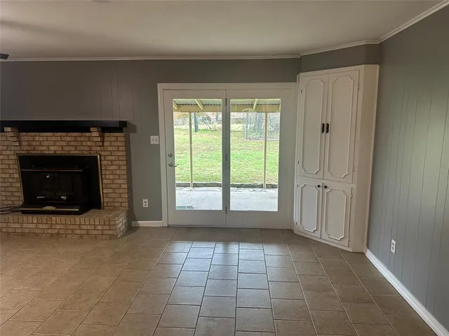 an empty room with windows and fireplace