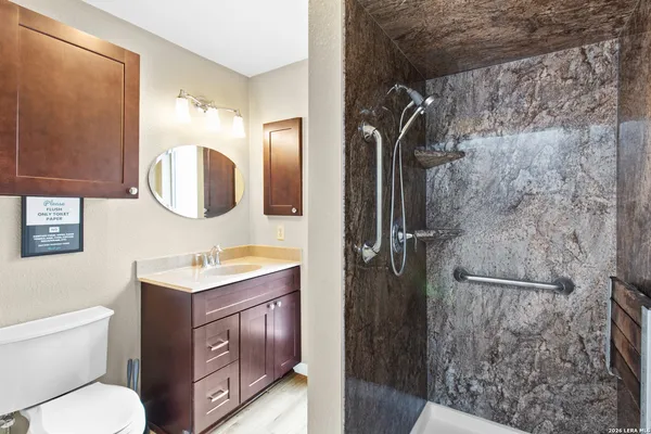 a bathroom with a toilet a sink and mirror