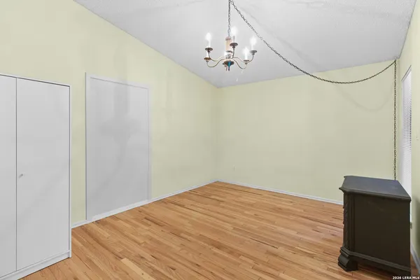 a view of a room with wooden floor and chandelier