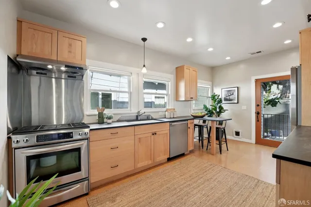 a kitchen with stainless steel appliances granite countertop a stove a sink a microwave and a refrigerator