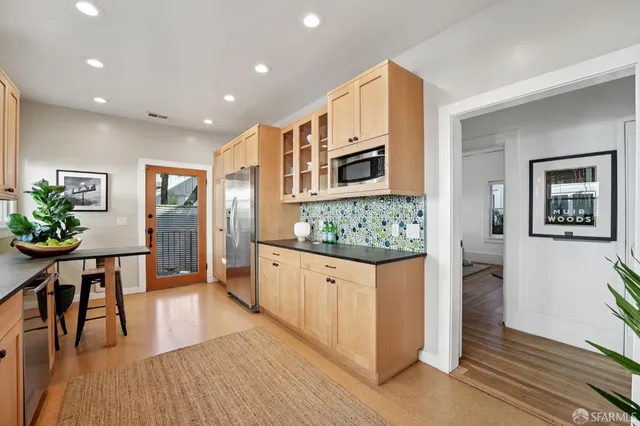 a kitchen with stainless steel appliances granite countertop a sink and a refrigerator