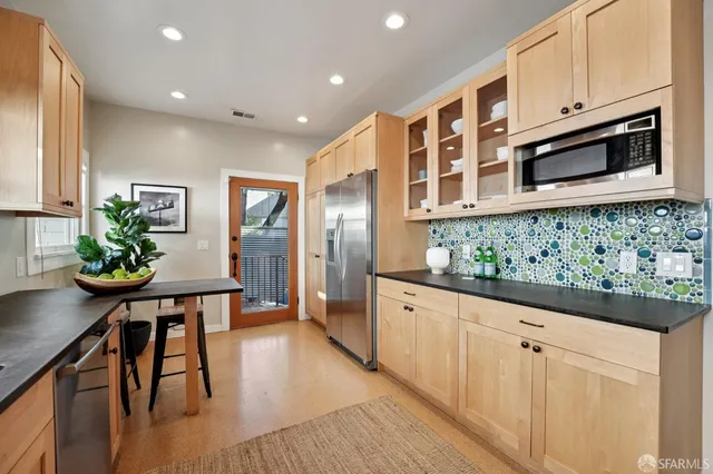 a kitchen with stainless steel appliances granite countertop a sink a stove and wooden floors