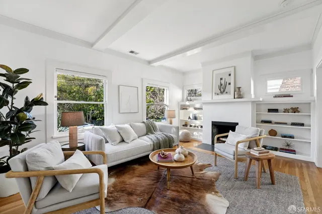 a living room with furniture a fireplace and a large window